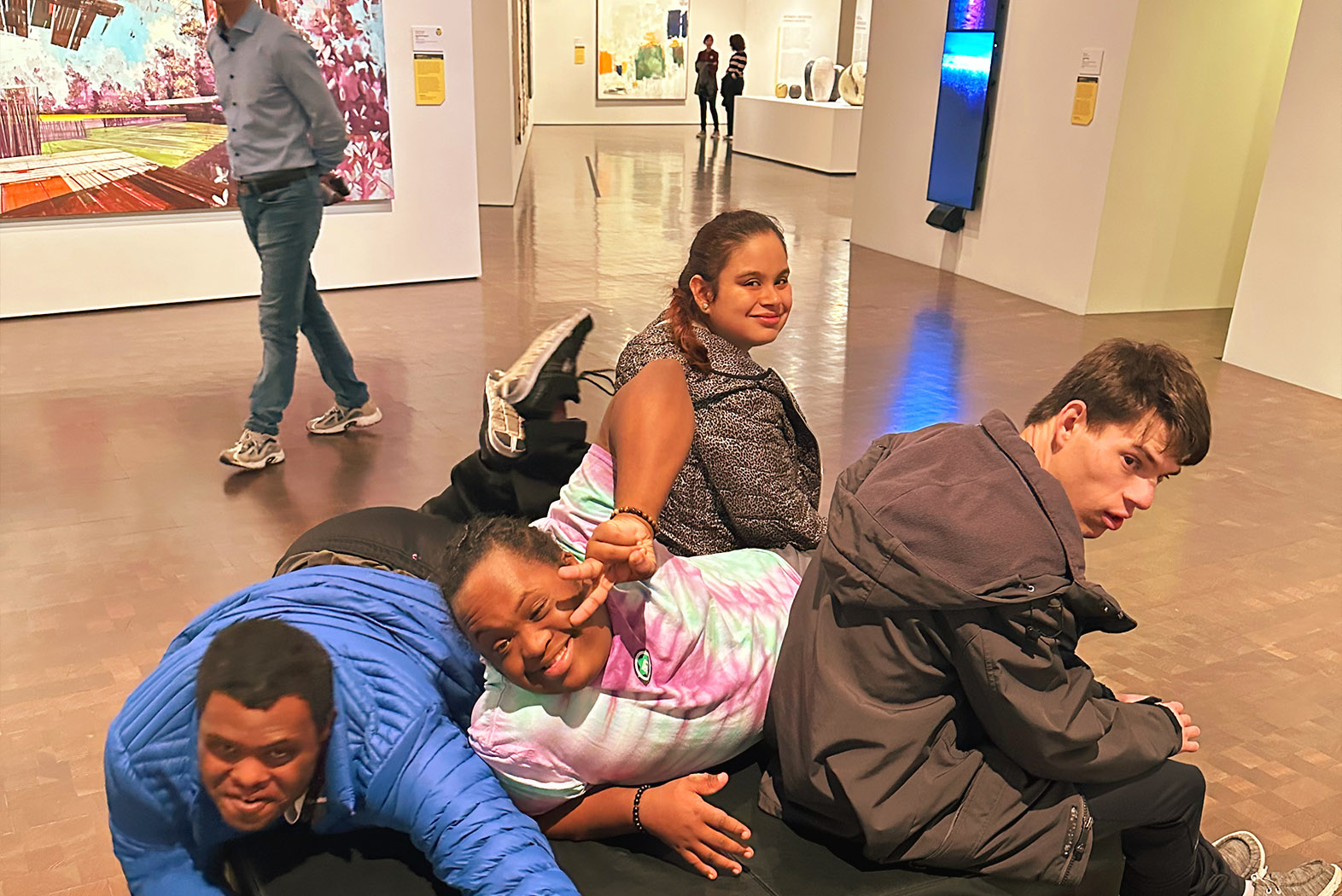 young adults sitting on a bench at an art gallery
